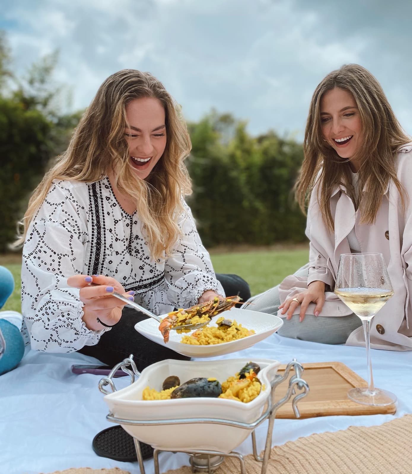 Dos amigas comparten paella en un picnic