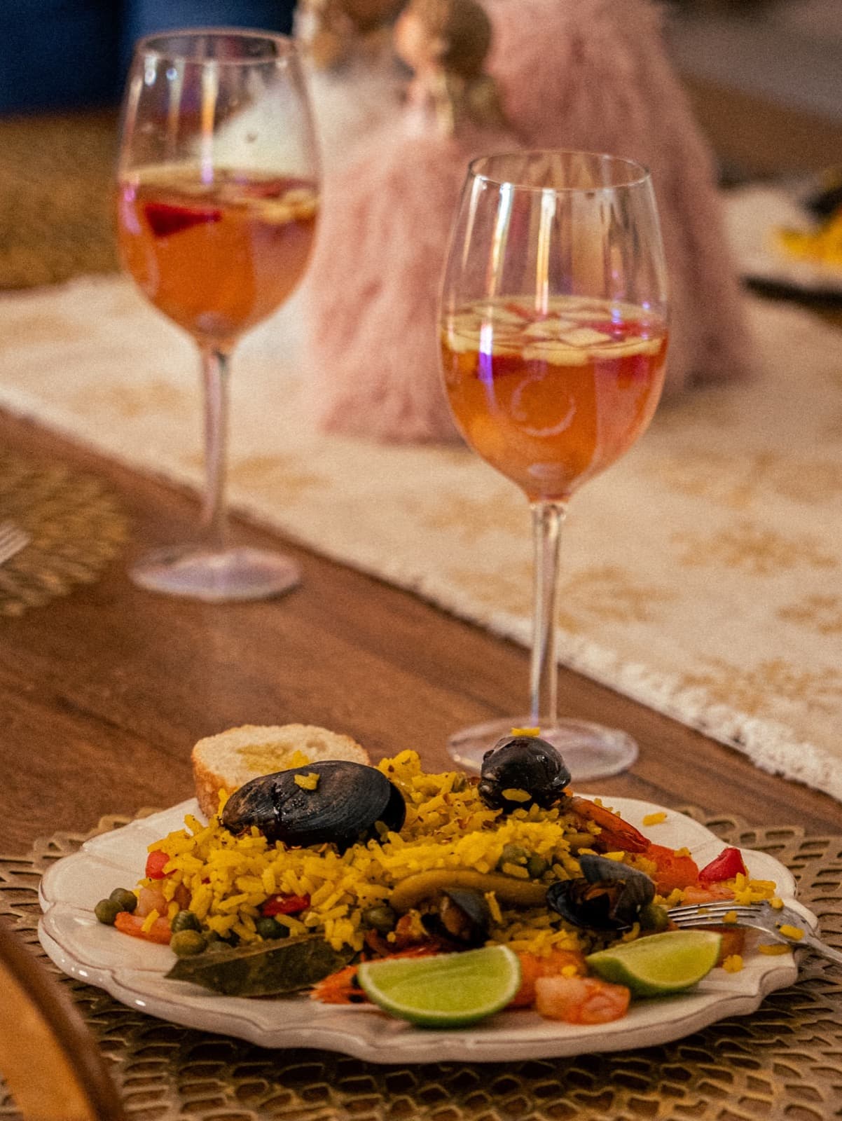 Plato de paella con limón y dos copas de sangría